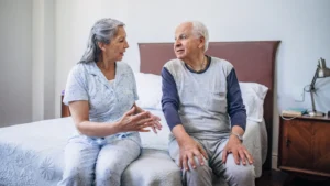 seniorzy siedzący na łóżku i wybierający wygodny materac do spania